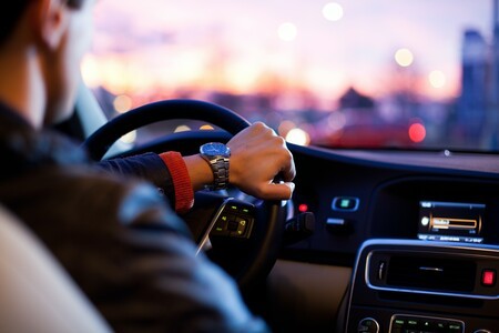 man driving electric vehicle with city in backround