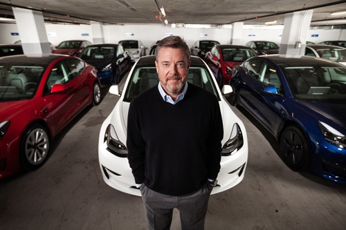 Scott painter standing in front of a Tesla model 3